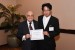 Dr. Nagib Callaos, General Chair, giving Mr. Haruka Hino the best paper award certificate of the session "Biomedical Engineering I." The title of the awarded paper is "Effect of Ultrasonic Vibration on Proliferation and Differentiation of Cells."